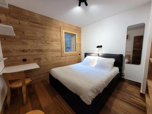 une chambre avec un lit et un bureau dans l'établissement Résidence PremiÈre Loge - appartement récent, belle piece de vie, jacuzzi avec vue MAE-3441, aux Gets