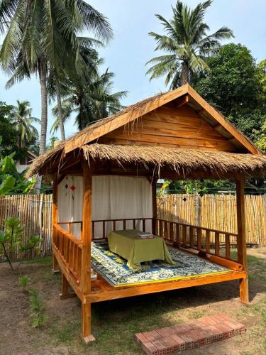 a wooden gazebo with a thatched roof at Moukdavan Guesthouse in Luang Prabang