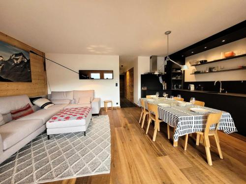 un salon avec un canapé, une table et des chaises dans l'établissement Résidence PremiÈre Loge - appartement récent, belle piece de vie, jacuzzi avec vue MAE-3441, aux Gets
