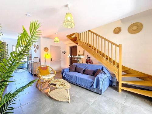 a living room with a blue couch and a staircase at Ti Kaz Sékoya - villa 2 chambres - Saint- Pierre in Casabona