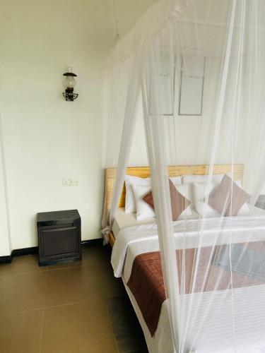 a bedroom with a bed with a mosquito net at Idyll Cottage Ella in Ella