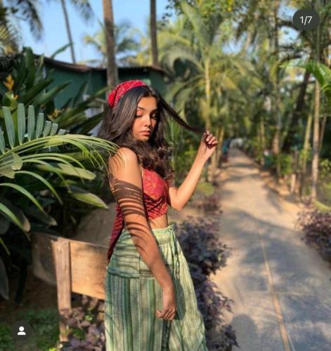 a woman in a dress standing on a road at Village Susegat Beach Resort in Morjim