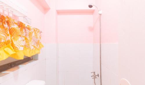 a bathroom with a shower with yellow towels on a wall at RedDoorz at LYOTO Bed and Breakfast near NAIA Terminal in Manila