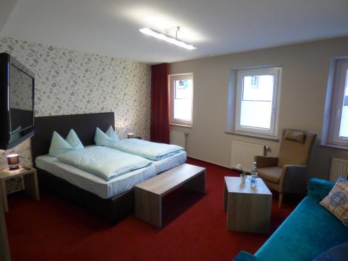 Habitación de hotel con cama y sofá en Zum Kronprinzen Hotel Garni, en Weyher