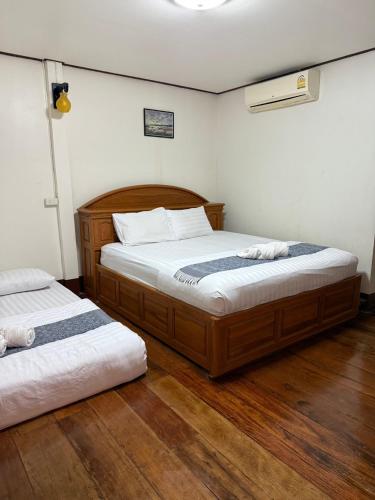 two beds in a room with wooden floors at กาลครั้งหนึ่ง ณ เชียงคาน (Once Upon A time) in Chiang Khan