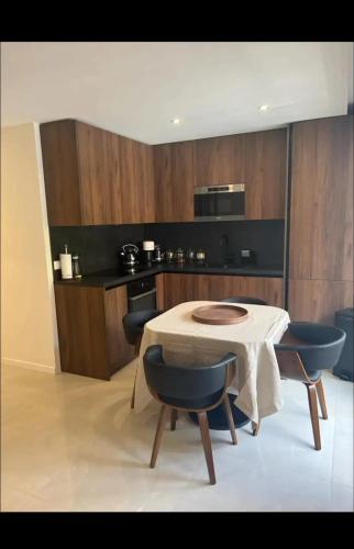 une cuisine avec une table et deux chaises ainsi qu'une cuisine avec une cuisinière dans l'établissement Appartement confortable à Neuilly-sur-Seine 43 m² avec balcon, à Neuilly-sur-Seine