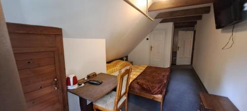 a small room with a bed and a table in it at Pension Dřevěnka in Harrachov