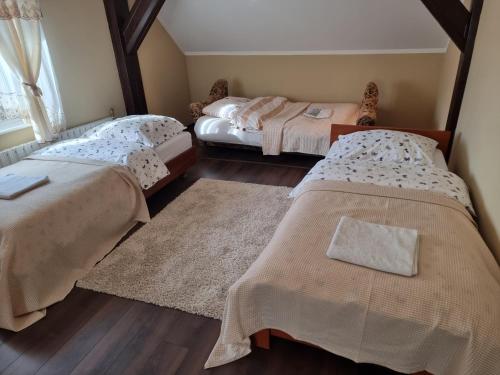 a bedroom with two beds and a rug at U Władzia in Wejherowo