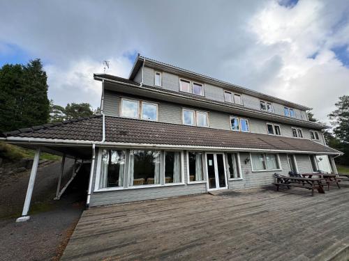 a large house with a bench on a wooden deck at Agder Folkehøgskole - Gjestehus in Kristiansand