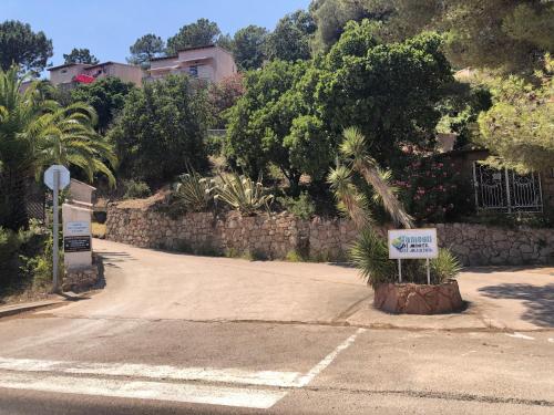 un panneau dans un parking avec un palmier dans l'établissement Duplex vue mer EXCEPTIONNELLE en Corse du sud proche plage - le 180Corse, à Conca