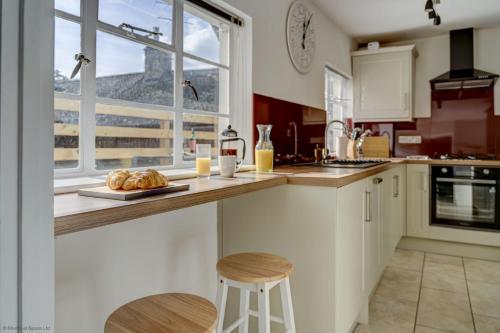 a kitchen with a counter with a plate of bread at Market Place Cottage in Woodstock