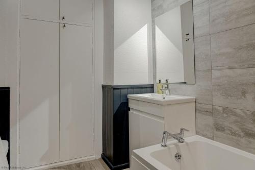a bathroom with a sink and a tub and a mirror at Market Place Cottage in Woodstock