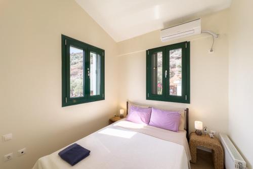 una camera da letto con letto con cuscini e finestre viola di villa with great seaview a Ambelón