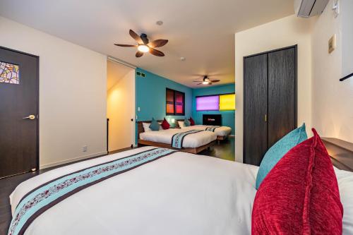 a bedroom with two beds and a ceiling fan at 1688House美ら海 in Motobu