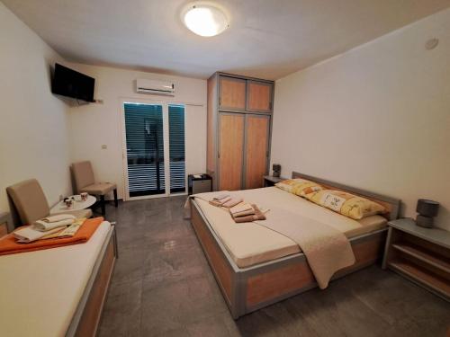 a bedroom with a bed and a television in it at Rooms Katja in Gradac