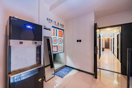 a room with a television and a hallway at BeiJing Seeyou Hostel -Close to the city center Near Subway Line 10 Sanyuanqiao,Close to Sanlitun,Yonghe Lama Temple,Tourism service in Beijing