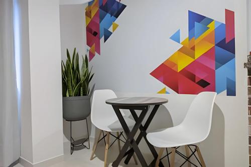 a table and chairs in a room with a painting at Near the UIS, stadium, la mercy clinic WIFI 225Mbp in Bucaramanga