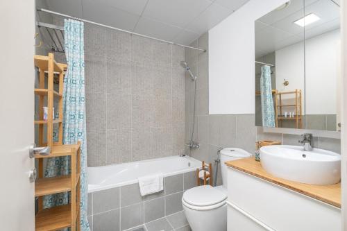 a bathroom with a sink and a toilet and a tub at Free housekeeping visits during your stay - StayShort - Cozy 1-Bedroom Apartment in Summer Residences JVC in Dubai