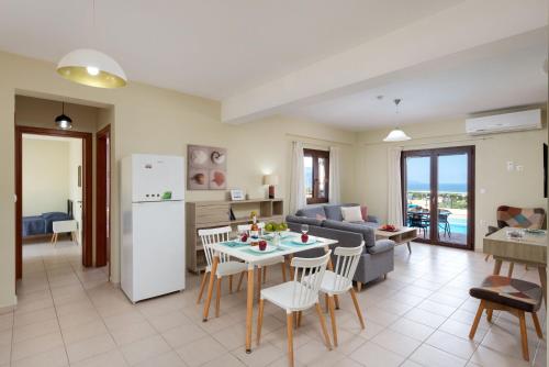a kitchen and living room with a table and a refrigerator at Villa Stratianna by PosarelliVillas in Módhion