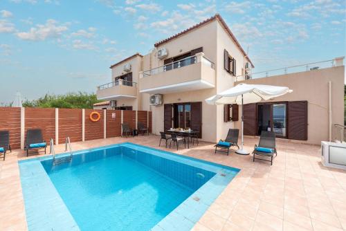 a villa with a swimming pool and a house at Villa Stratianna by PosarelliVillas in Módhion