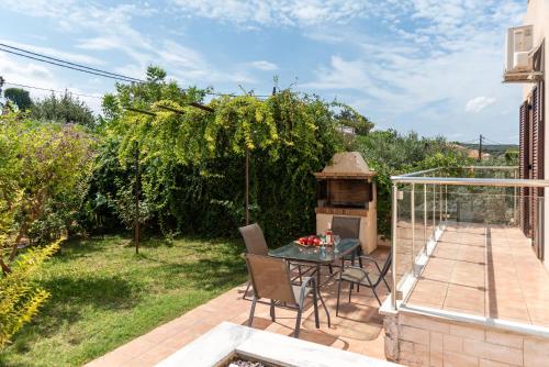 a patio with a table and a grill at Villa Stratianna by PosarelliVillas in Módhion