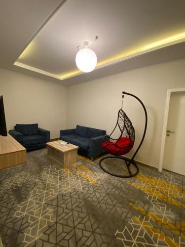 a living room with a couch and a red chair at Golden New Tulip Abha in Abha