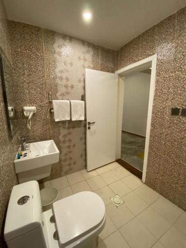 a bathroom with a toilet and a sink at Golden New Tulip Abha in Abha