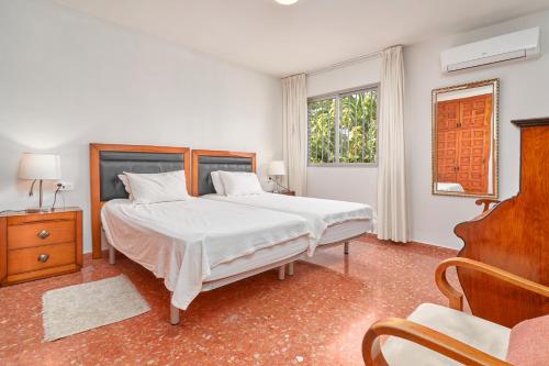 a bedroom with a bed and a chair and a window at Apartamento Sol de la Molina in Salobreña
