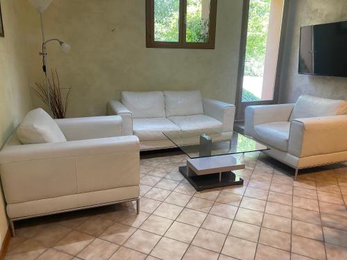 a living room with two couches and a coffee table at Maison 3 chambres, 3 SdB, terrasse, piscine, spa in Meyrié