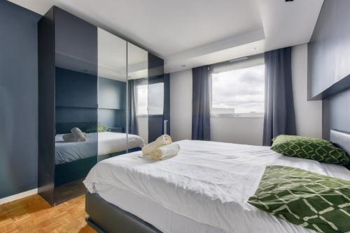 une chambre avec deux lits et un grand miroir dans l'établissement Beautiful 1 bed flat at La Défense Near Metro 1, à Courbevoie