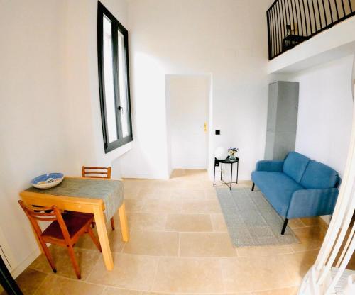 un soggiorno con un divano blu e un tavolo di Maison Spacieuse au Bord du Lez, 5pers, Calme, Wi-Fi, Jardin Privé, Parking Gratuit a Montpellier