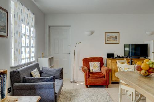 a living room with a couch and a chair and a table at Station Cottage in Long Hanborough