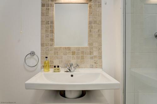 a bathroom with a white sink and a shower at Station Cottage in Long Hanborough