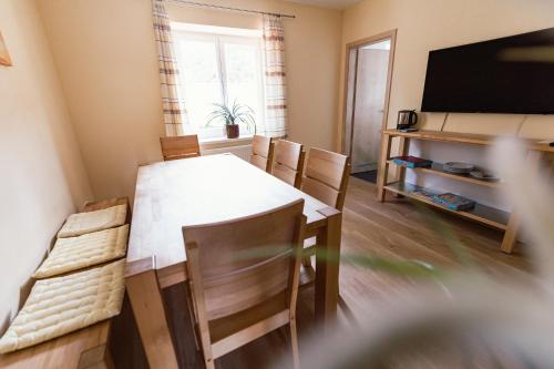 a dining room with a table and chairs and a television at Frühstückspension Spitzauer in Nittendorf