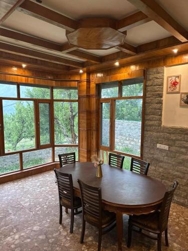 a dining room with a large wooden table and chairs at Amarys Boutique Stays Manali in Manāli