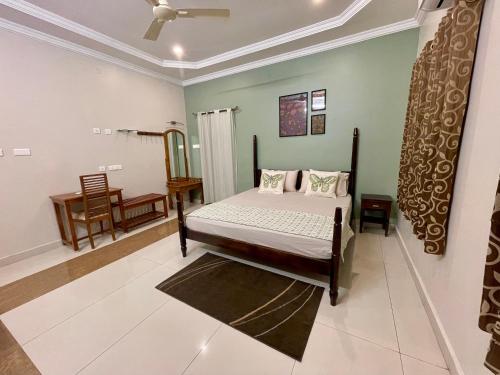 a bedroom with a bed and a chair in it at SaiSumam in Tirupati