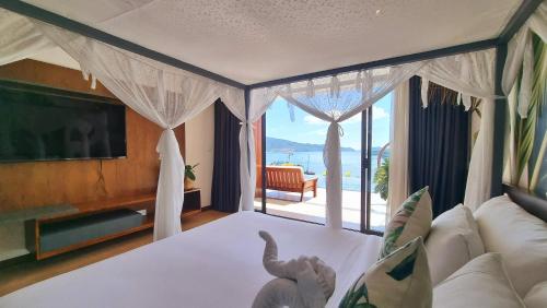 a living room with a bed and a large window at Anh Nguyen Oceanfront Luxury Villas Nha Trang in Nha Trang