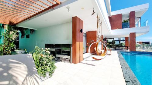 an outdoor patio with a swimming pool and a house at Anh Nguyen Oceanfront Luxury Villas Nha Trang in Nha Trang