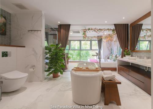 a bathroom with a tub and a toilet and a sink at Anh Nguyen Oceanfront Luxury Villas Nha Trang in Nha Trang