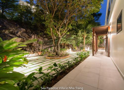a walkway next to a building with a tree at Anh Nguyen Oceanfront Luxury Villas Nha Trang in Nha Trang
