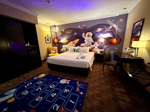 a hotel room with a bed with a childs astronaut themed bedroom at Merchant Hotel in George Town