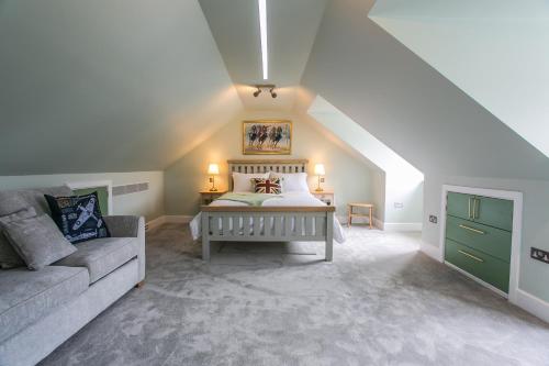 a attic bedroom with a bed and a couch at La Flora -Bracklesham Bay in Chichester