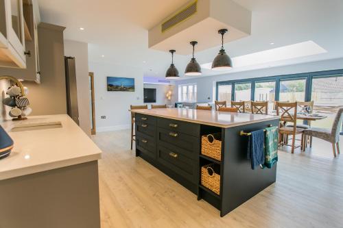 a kitchen with a large island in the middle at La Flora -Bracklesham Bay in Chichester