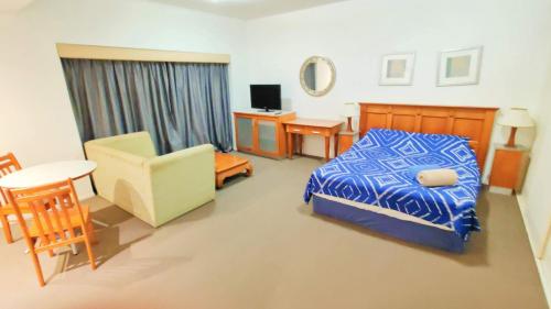 une chambre avec un lit, une table et une chaise dans l'établissement HILLTOP CBD SUITES, à Brisbane