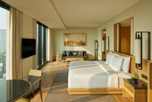 a hotel room with a large bed and a living room at Hotel Tentrem Jakarta in Serpong