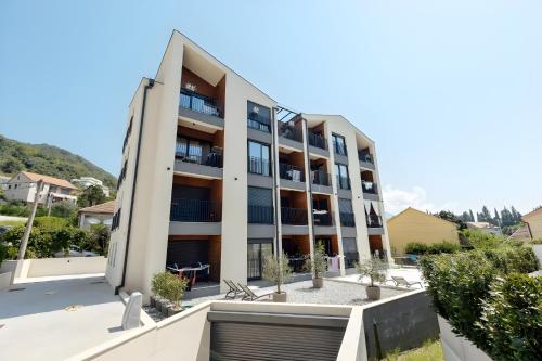 an apartment building with balconies and plants at Fides Stylish Apartments Tivat with Pool in Tivat
