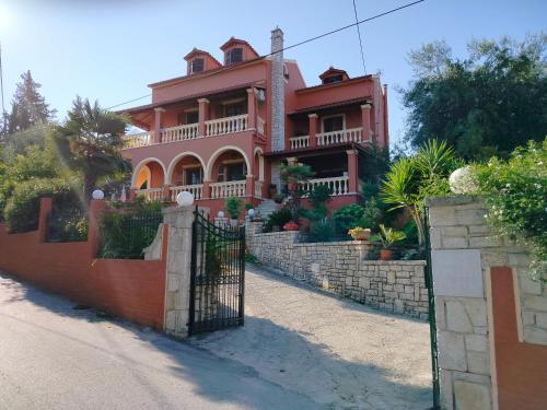 a pink house with a gate in front of it at Seaside Pool Villa in Mesongi