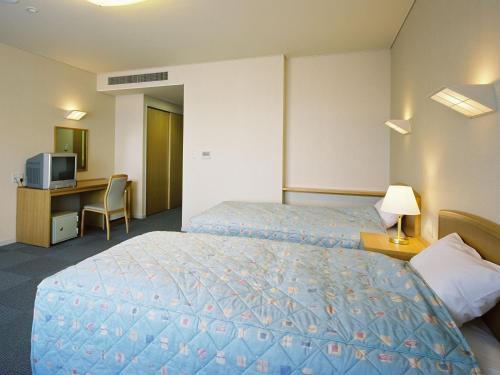 a hotel room with a bed and a desk at 公共の宿伊豆まつざき荘 in Matsuzaki