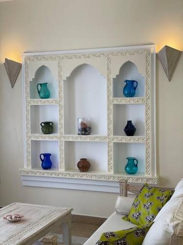 a white shelf with blue vases in a living room at Villa Macheo in Mombasa