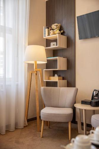 a living room with a chair and a lamp at Pytloun Kampa Garden Hotel Prague in Prague
